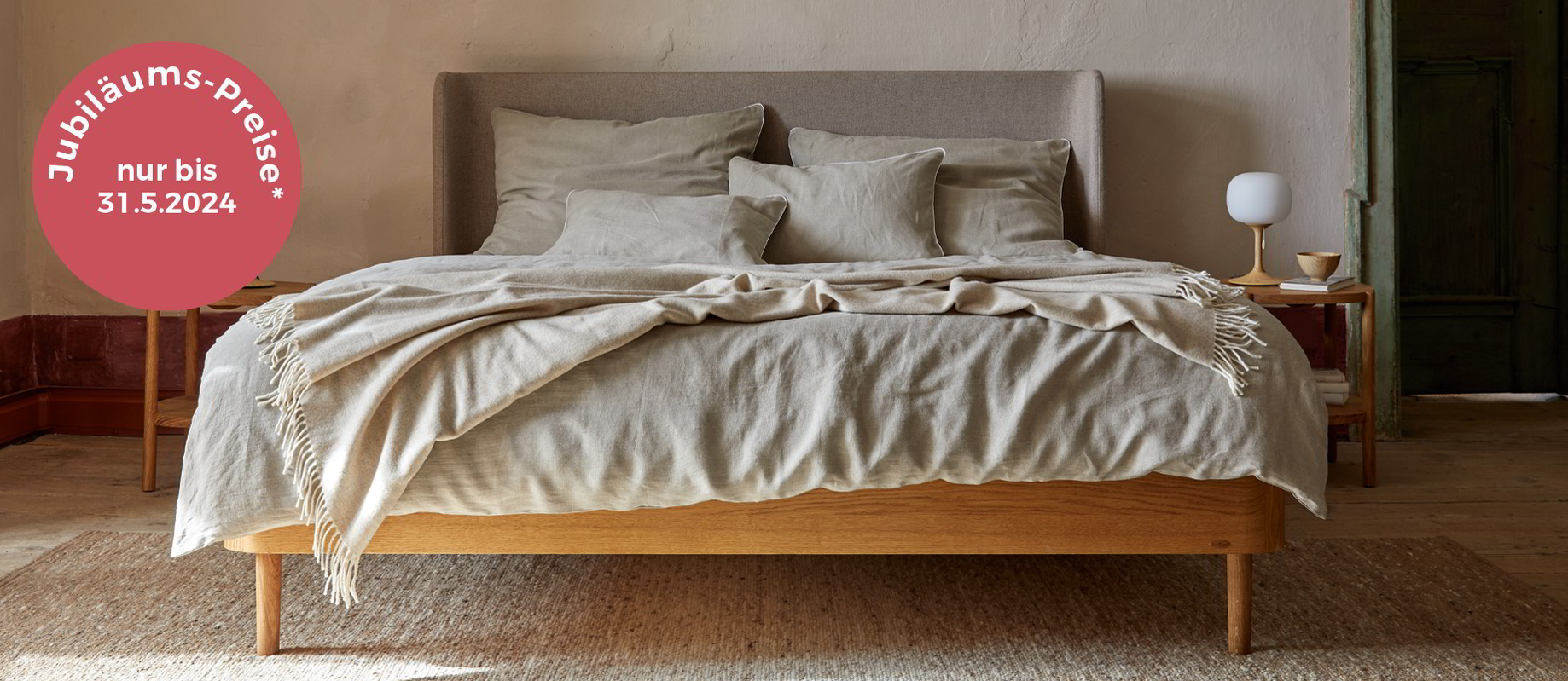Holzbett mit Polsterbetthaupt steht auf beigem Teppich, Jubiläumspreise
